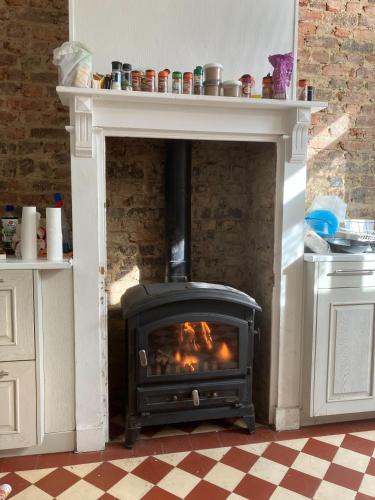 une cheminée avec un poêle dans une cuisine dans l'établissement Grande maison de ville 8 places, à Amiens