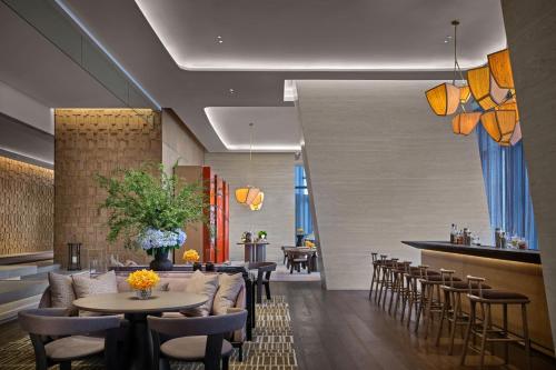 a restaurant with tables and chairs and a bar at Rosewood Guangzhou, enjoy free shuttle bus service between the hotel and the Canton Fair Complex during the Canton Fair in Guangzhou