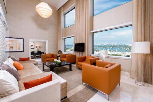 uma sala de estar com mobiliário laranja e janelas grandes em InterContinental Miami, an IHG Hotel em Miami