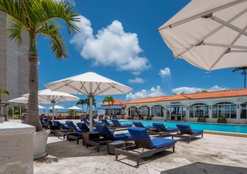 a pool with chairs and umbrellas next to a resort at InterContinental Miami, an IHG Hotel in Miami