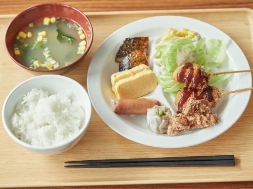a tray with a plate of food and a bowl of soup at EZ HOTEL Kansai Airport Seaside in Izumi-Sano