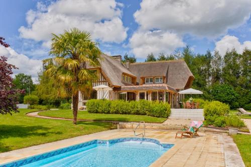 une maison avec une piscine et une maison dans l'établissement La Chaumière - Tennis & Swimming Pool - Branville, à Branville