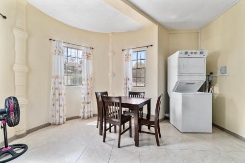 a kitchen with a table and chairs and a refrigerator at Kaibus Place K3 2/bedroom in Morne Rouge