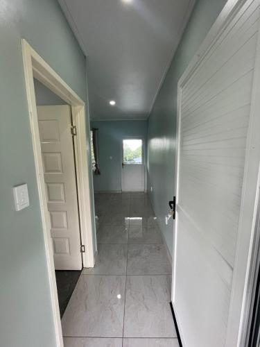 a hallway with a white door and a tile floor at Moalela'i Accommodation in Apia