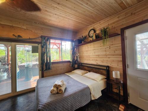um quarto com uma cama num quarto de madeira em cabin 6 new cottage with private hot tub em Fern Forest