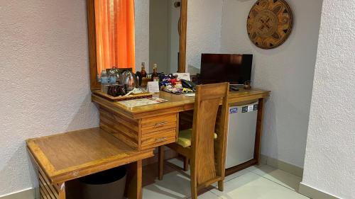 CITI HOTEL في Hilongos: مكتب خشبي وبه جهاز كمبيوتر ومرآة