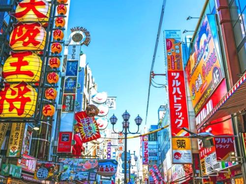 a busy city street with many signs and buildings at EZ HOTEL Kansai Airport Seaside in Izumi-Sano