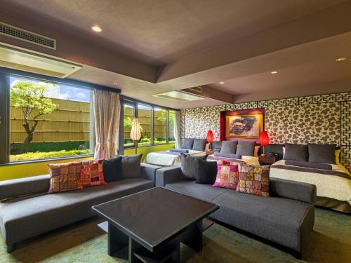 ein Wohnzimmer mit einem Sofa und einem Bett in der Unterkunft Rose Hotel Yokohama, The Distinctive Collection By WORLDHOTELS in Yokohama