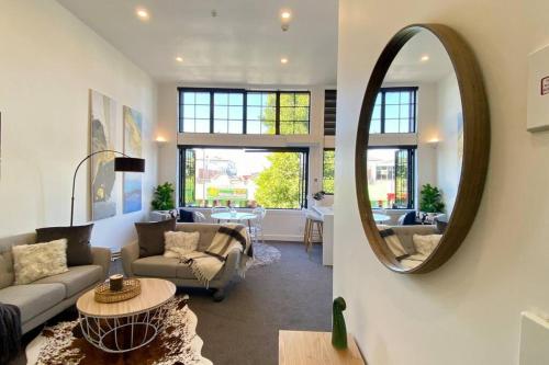 a living room with a couch and a mirror at The Statesman in Hamilton