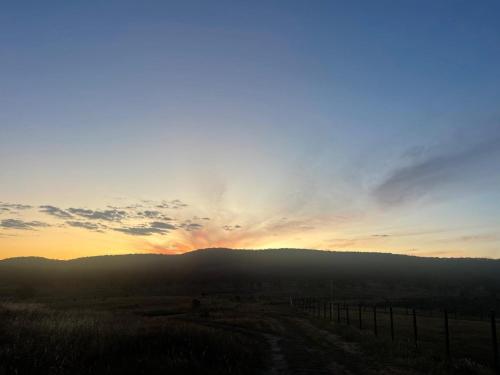 a sunset with the sun setting over a hill at Clover at Lexington Park by Tiny Away in Tarlo