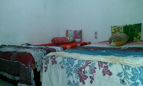 two beds sitting next to each other in a room at Diyah Homestay in Kuta Lombok