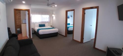 a hotel room with a bed and a couch at Centrepoint Motel Deniliquin in Deniliquin