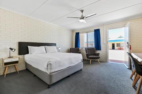 um quarto com uma cama, uma mesa e cadeiras em Comfort Inn on Main Hervey Bay em Hervey Bay