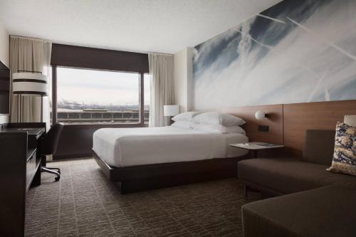 a hotel room with a bed and a couch at Newark Liberty International Airport Marriott in Newark