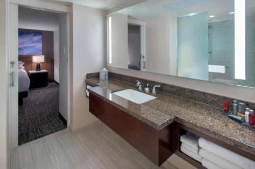 a bathroom with a sink and a large mirror at Newark Liberty International Airport Marriott in Newark