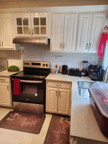 a kitchen with white cabinets and a black stove at palmview estate townhouse in Mammee Bay