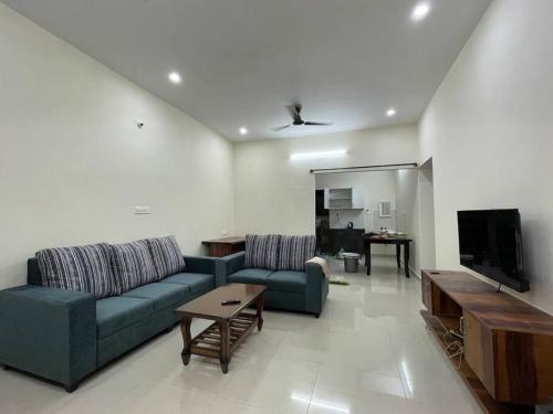 salon z kanapą i telewizorem w obiekcie SSN Home Stays in Bangalore near PLAY Arena w mieście Bengaluru