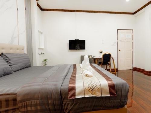 sypialnia z łóżkiem, biurkiem i telewizorem w obiekcie 2B Cozy Hostel ตรัง w mieście Trang