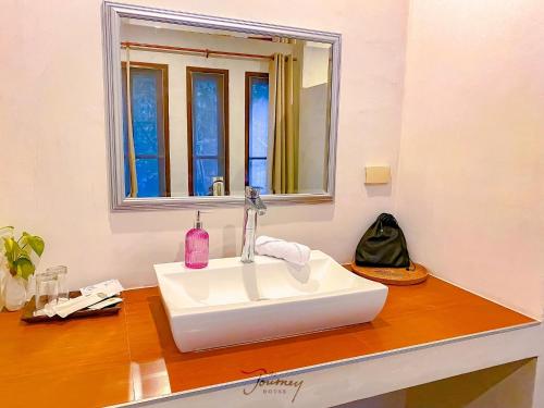 a bathroom with a white sink and a mirror at The Journey House Lifestyle Boutique Hotel in Kanchanaburi