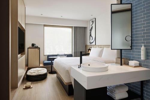 um quarto de hotel com uma cama e um lavatório em Fairfield by Marriott Kagoshima Sakurajima em Tarumizu