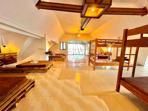 On Board Panglao Beach Hostel & Resort في داؤو: غرفة كبيرة بها عدة أسرة وغرفة معيشة