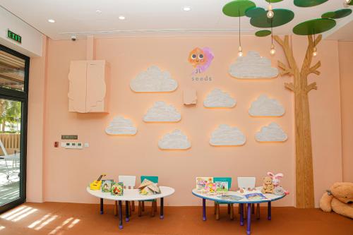 two tables in a room with clouds on the wall at Melia Ho Tram Beach Resort in Ho Tram