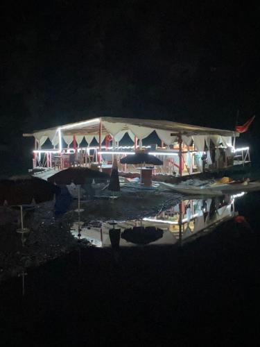 a building lit up at night with lights at Park Blini Shala River in Mollʼ e Shoshit