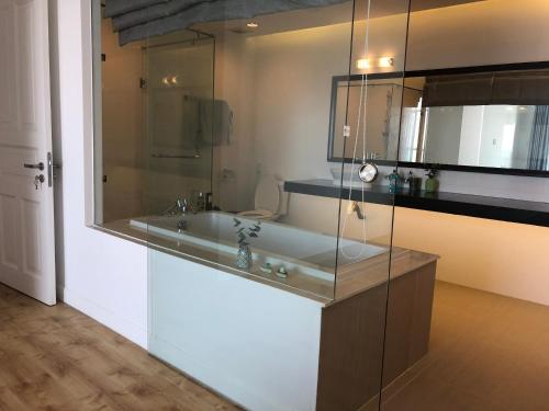 a bathroom with a tub and a glass wall at Hotel,Căn Hộ Mũi Né Sea link in Phan Thiet
