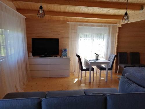 a living room with a couch and a table and a tv at Rangi Suvemaja in Hiiumaa