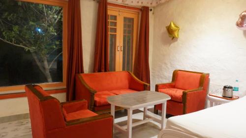 a living room with two chairs and a table at Wow Relish in Alwar