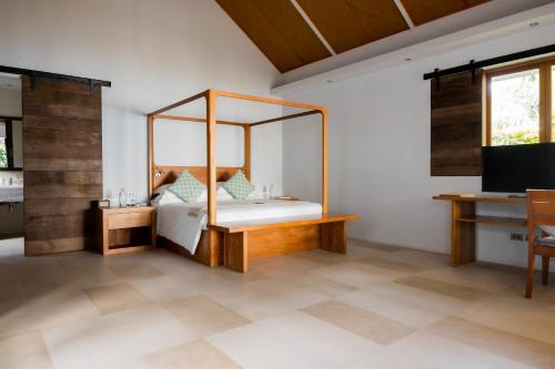sypialnia z łóżkiem, biurkiem i telewizorem w obiekcie The Cove w mieście Panwa Beach