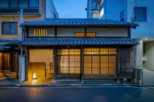 a building with two doors with a light in front at Nishijin Isa Machiya Holiday House in Nishijin