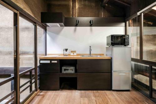 a kitchen with a sink and a refrigerator at Nishijin Isa Machiya Holiday House in Nishijin
