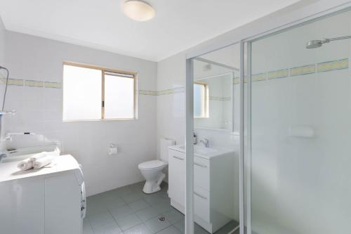 ein weißes Badezimmer mit Dusche und Toilette in der Unterkunft Blue Waters Apartments in Eden