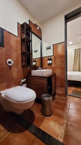 a bathroom with a toilet and a sink at Forest Escapes Koyna in Koynanagar