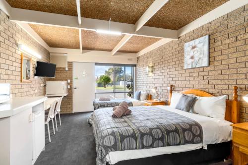 ein Hotelzimmer mit 2 Betten, einer Küche und einer Theke in der Unterkunft Baronga Motor Inn in Colac
