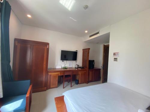 1 dormitorio con 1 cama y escritorio con TV en Twins Hotel, en Ho Chi Minh