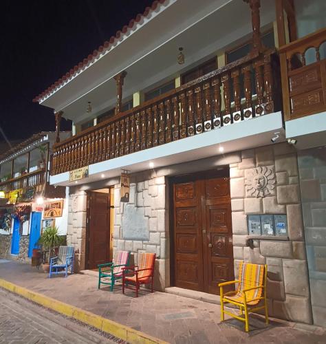 a group of colorful chairs sitting outside of a building at Hotel Inka Pisac in Pisac