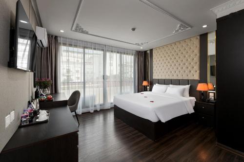 a bedroom with a large white bed and a large window at Avani Central Hanoi Hotel in Hanoi
