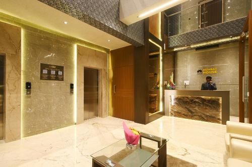 a lobby with a pink bird sitting on a glass table at Mumbai House Luxury Apartments Santacruz East, Mumbai in Mumbai