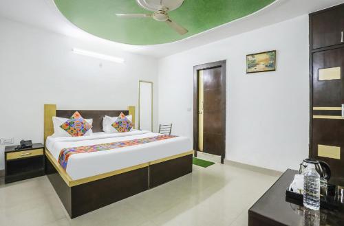 1 dormitorio con 1 cama grande y techo en FabHotel BR International en Agra