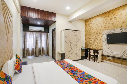 ein Hotelzimmer mit einem Bett und einem TV in der Unterkunft FabExpress Sky Maulshree in Raipur