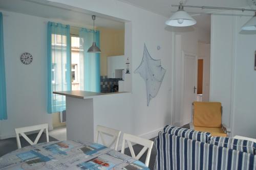 une cuisine avec une table et des chaises dans une pièce dans l'établissement Marguerite, à Saint-Malo