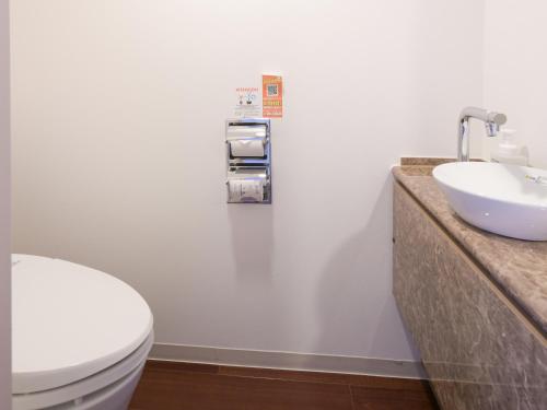 een badkamer met een wit toilet en een wastafel bij Vessel Inn Sapporo Nakajima Park in Sapporo