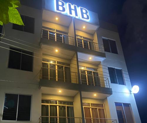 a building with a big sign on it at night at BHB - ApartaHotel in Leticia