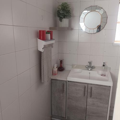 uma casa de banho com um lavatório e um espelho em MaThwala guesthouse em Vanderbijlpark