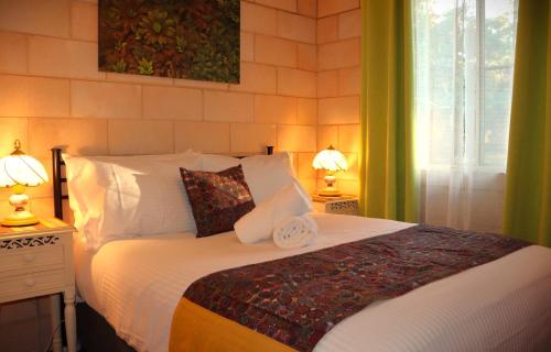 a bedroom with a bed with two lamps and a window at Severn River Cottages in Severnlea
