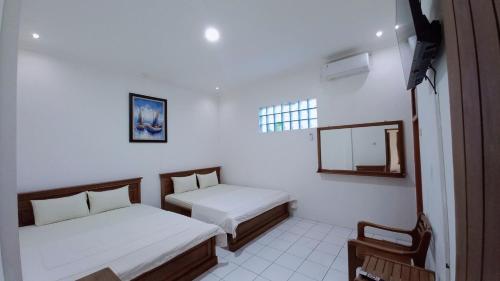 a small room with two beds and a window at Nusawiru Guest House in Pangandaran
