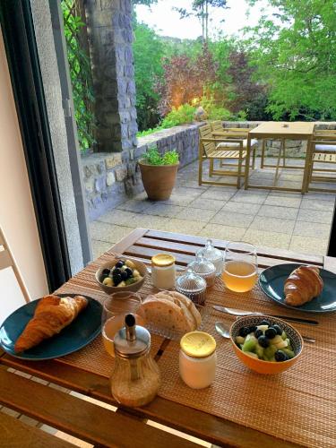 een tafel met brood en croissants en andere ontbijtproducten bij L'Auberge du Ranc in Saint-Sèbastien