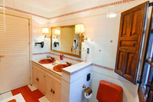W łazience znajduje się umywalka, lustro i toaleta. w obiekcie Casa Rural El Mirador del Pico w mieście Santa Cruz del Valle